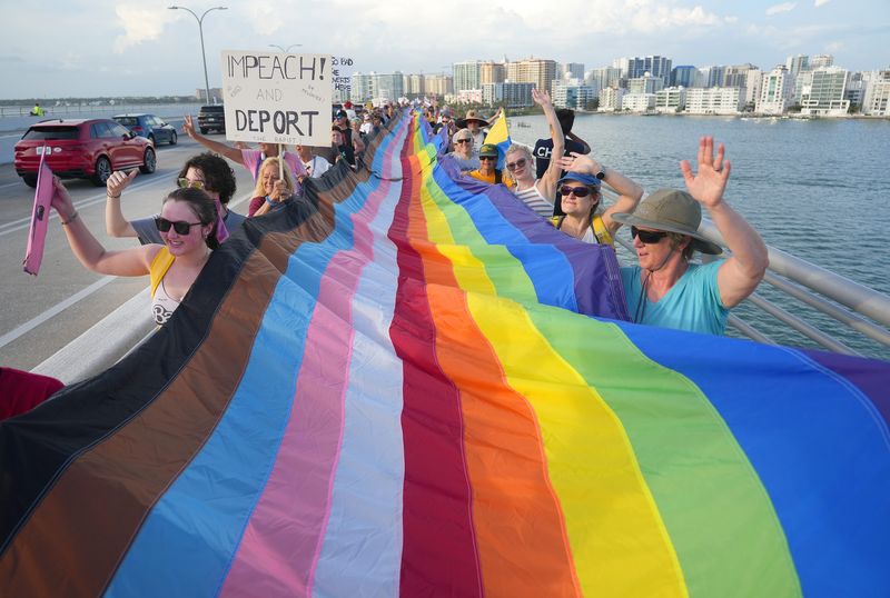 An estimated 7,000 people gathered along Sarasota's bayfront for a 'No King's' protest on June 14, 2025. The rally featured numerous speakers, a 700-foot pride flag and a parade across Ringling Bridge.