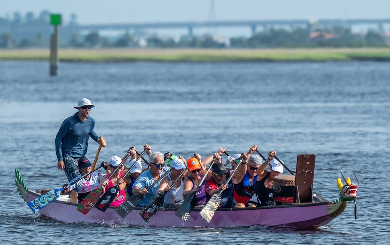 Steerer Mark Dew, far left, yells out the stroke cadence as members of the Jacksonville Dragon Boat Club train off Jacksonville Beach. They will be taking part in the World Dragon Boat Racing Championships in Germany in July in the first Breast Cancer Paddler division to be included in the competition.