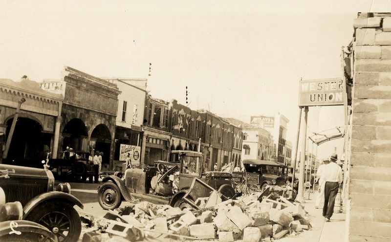 A West Palm Beach street following the 1928 hurricane. A Western Union telegraph office can be seen to the right and the tall building on the left at the other end of the street is Anthony's clothing store.