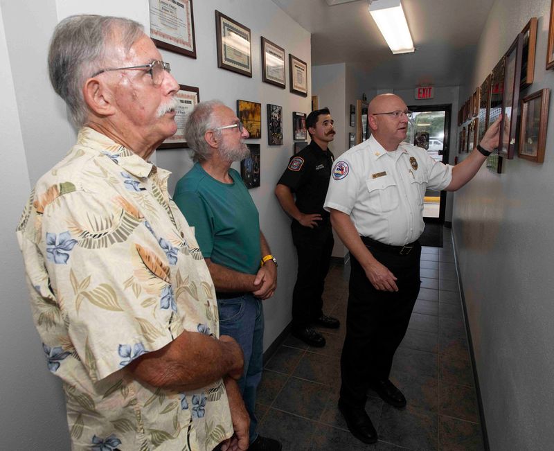 Former Warrington Volunteer Firefighters help Escambia County Fire Rescue Chief Adam Harrison select a space for the county proclamation declaring the transfer of the firehouse to the county on June 17, 2025.