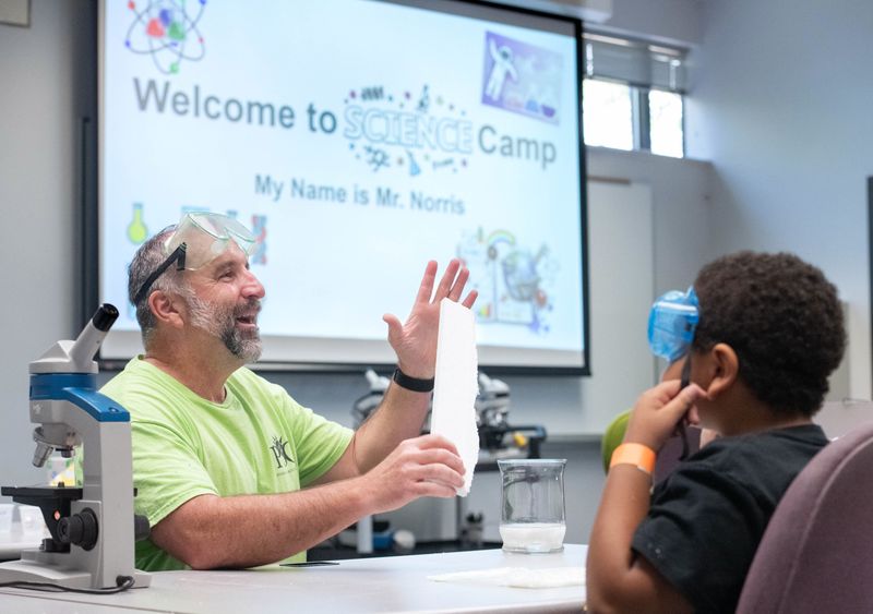 Science instructor Chris Norris, left, gives instructions on how to dissolve a piece of styrofoam in acetone during Kids College summer camp at Pensacola State College on June 17, 2025.