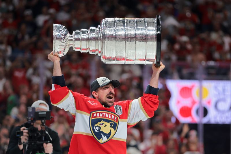 Florida Panthers center Brad Marchand hoists the Stanley Cup after winning Game 6 of the 2025 Stanley Cup Final at Amerant Bank Arena on June 17, 2025 in Sunrise, Florida.