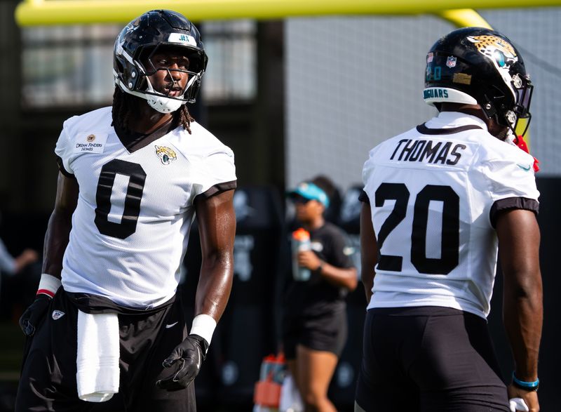 Jacksonville Jaguars linebacker Devin Lloyd (0) talks with teammate Jacksonville Jaguars safety Daniel Thomas (20) during stretching during the Jacksonville Jaguarsâ€™ third mandatory minicamp Thursday June 12, 2025 at the Miller Electric Center in Jacksonville, Fla. [Doug Engle/Florida Times-Union]