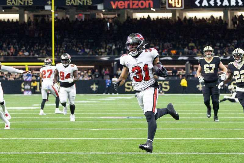 Oct 13, 2024; New Orleans, Louisiana, USA; Tampa Bay Buccaneers safety Antoine Winfield Jr. (31) return a fumble for a touchdown against New Orleans Saints wide receiver Chris Olave (12) during he first half at Caesars Superdome. Mandatory Credit: Stephen Lew-Imagn Images