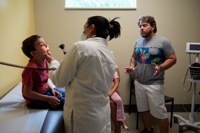 Ariange Ramirez, a pediatric APRN, examines Kendrick Zorrilla,7, during a recent check-up as his father, Kerwin Zorrilla stands by at the Women and Children's Health Center on 17th St. in Sarasota.