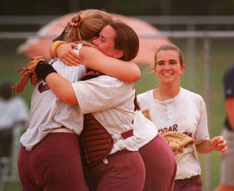 Cardinal Mooney's catcher Marcia O'Gorman hugs Kristina Eder after winning the Class 3A Championship Friday against John Carroll. Mooney beat Carrol 3-0 .