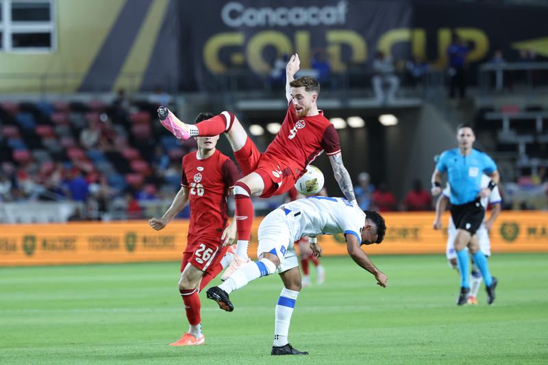 Jun 24, 2025; Houston, Texas, USA; Canada defender Joel Waterman (5) battles for the ball against El Salvador forward Rafael Tejada (14) during the second half during a group stage match of the 2025 Gold Cup at Shell Energy Stadium. Mandatory Credit: Troy Taormina-Imagn Images