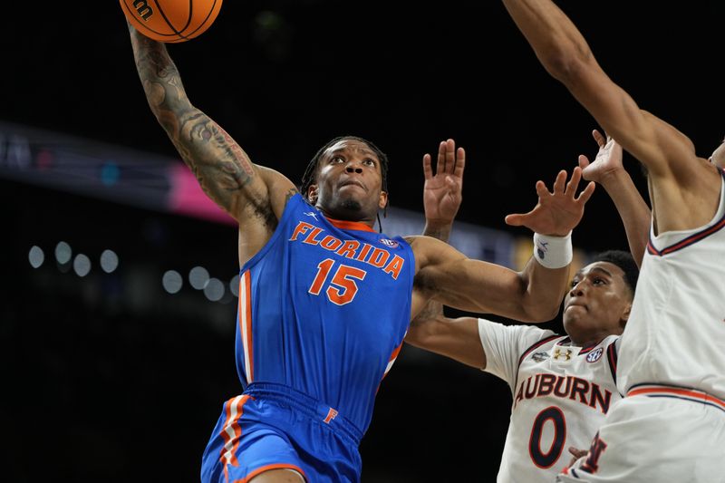 Apr 5, 2025; San Antonio, TX, USA; Florida Gators guard Alijah Martin (15) dunks the ball against Auburn Tigers guard Tahaad Pettiford (0) and guard Chad Baker-Mazara (10) during the second half in the semifinals of the men's Final Four of the 2025 NCAA Tournament at the Alamodome. Mandatory Credit: Bob Donnan-Imagn Images ORG XMIT: IMAGN-1026924 ORIG FILE ID: 20250405_jcd_sd2_0179.JPG