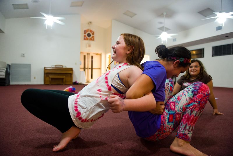 Katie Grim (left), 11, of Palm City, and instructor Caitlin Plummer, of Port St. Lucie, perform a demanding partnered yoga pose during a yoga class for children in the sixth through eighth grade Thursday, Jan. 7, 2016, at the Episcopal Church of The Advent at 4484 SW Citrus Blvd., Palm City. "It's pretty cool we're doing this today," Plummer said, "because we did this in September, and none of us could do it." The free classes, sponsored by Tykes & Teens and the Children's Services Council of Martin County, run through May every Thursday from 5:30 to 6:30 p.m.
