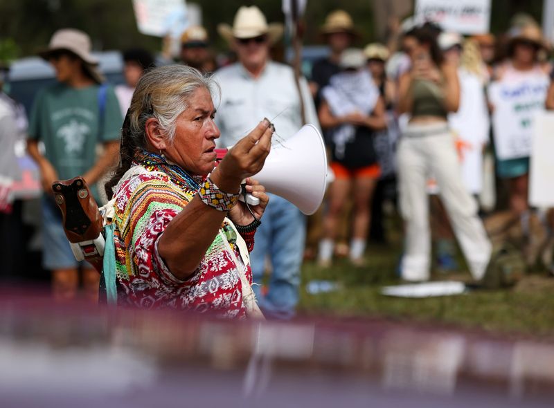 Betty Osceola, an activist and a Miccosukee tribe member, speaks to the crowd gathered in front of the access road into the Dade-Collier Training and Transition Airport to protest the construction of an immigrant detention center in the Big Cypress Wildlife Management Area on Saturday, June 28, 2025. The demonstration was led by Osceola. A steady stream of trucks were seen going into the location. The location is being referred to as "Alligator Alcatraz."