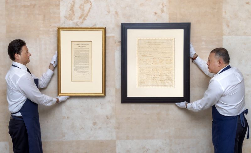 Sotheby's workers at the New York salesroom with the Emancipation Proclamation and the 13th Amendment, both hand-signed by Abraham Lincoln