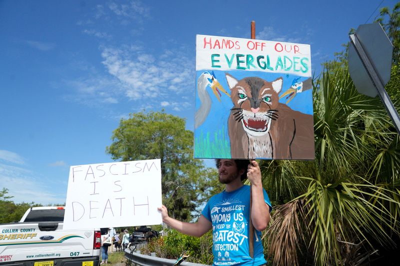 Protestors gather at the entrance of the Dade-Collier Training and Transition Airport on Tuesday, July 1, 2025. It is being transformed into a detention center that is known as “Alligator Alcatraz”.