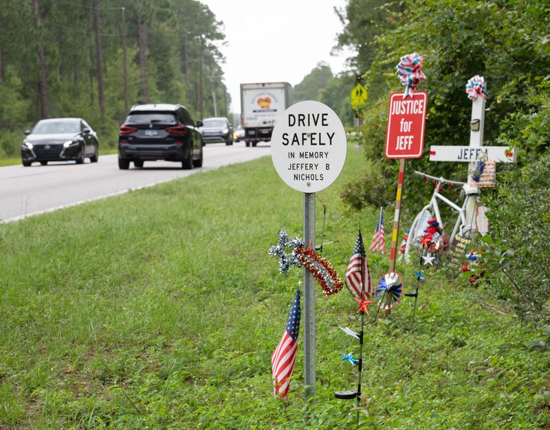 Traffic moves past a roadside memorial along Sorrento Road in Escambia County on July 1, 2025.