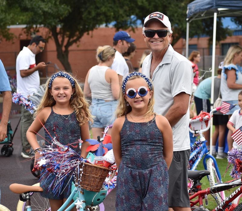 Kevin Guernsey helps his twin girls Sara and Sydney put a few finishing touches on their bikes before the Independence Parade on July 1.