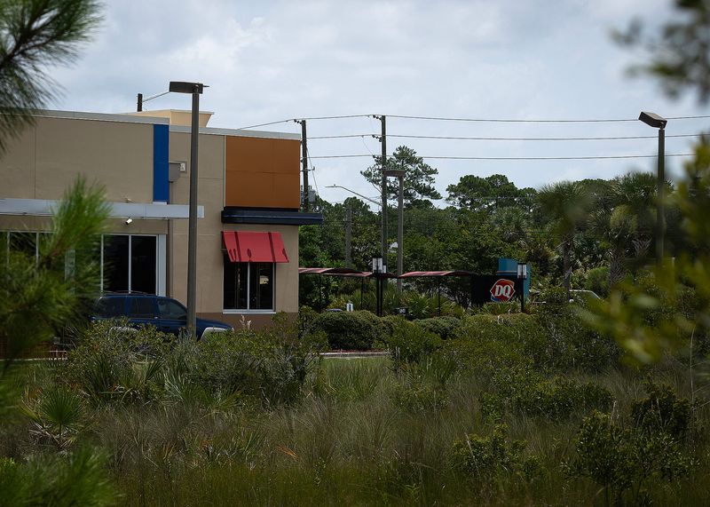 The Dairy Queen Grill & Chill on Alf Coleman Road in Panama City Beach, Fla., is seen from a nearby homeless encampment July 2, 2025. A decomposing body was found in the woods the previous day. (Tyler Orsburn/News Herald)