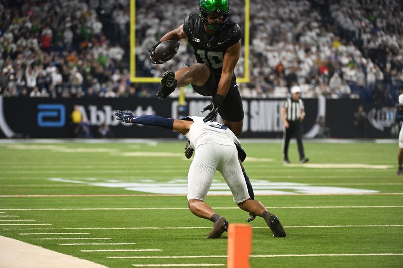 Dec 7, 2024; Indianapolis, IN, USA; Oregon Ducks tight end Kenyon Sadiq (18) hurdles Penn State Nittany Lions cornerback Jalen Kimber (3) for a touchdown during the first quarter in the 2024 Big Ten Championship game at Lucas Oil Stadium. Mandatory Credit: Robert Goddin-Imagn Images