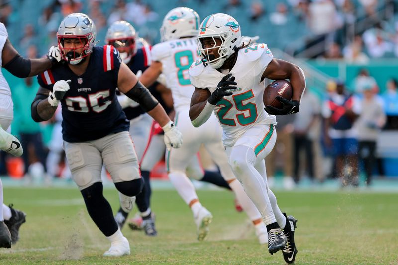Nov 24, 2024; Miami Gardens, Florida, USA; Miami Dolphins running back Jaylen Wright (25) runs with the football against the New England Patriots during the fourth quarter at Hard Rock Stadium. Mandatory Credit: Sam Navarro-Imagn Images