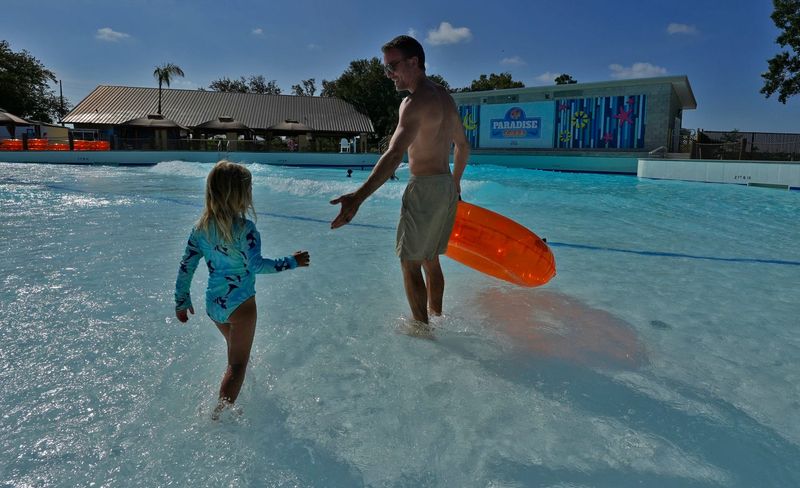 John Paul Opteyndt and his daughter Wren, 3, from Bonita Springs, enjoy the new wave pool attraction at Sun Splash Family Waterpark in Cape Coral Tuesday, July 8, 2025. The park unveiled its new wave pool attraction, Paradise Cove, and held a media tour of the facility.