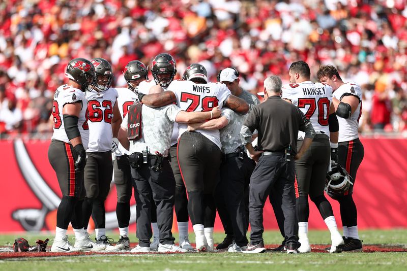 Nov 10, 2024; Tampa, Florida, USA; Tampa Bay Buccaneers offensive tackle Tristan Wirfs (78) is helped off the field by staff against the San Francisco 49ers in the second quarter at Raymond James Stadium. Mandatory Credit: Nathan Ray Seebeck-Imagn Images