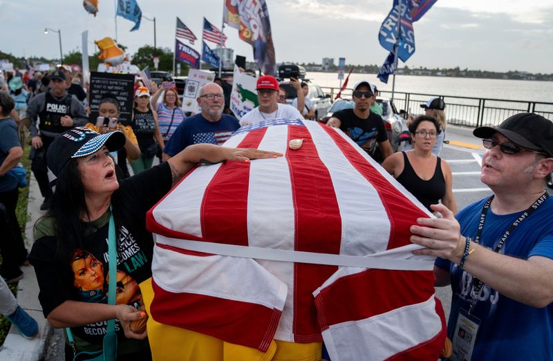 Protesters push a coffin symbolizing the death of democracy during the 'Good Trouble Lives On' national day of action against the administration of US President Donald Trump near Mar-a-Lago on July 17, 2025 in Palm Beach, Florida.