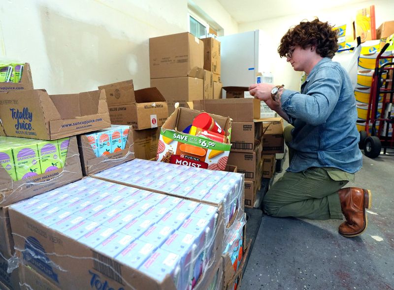 August Maulfair, food systems manager at the Neighborhood Center food pantry in DeLand, sorts through donated food on Monday, July 21, 2025.