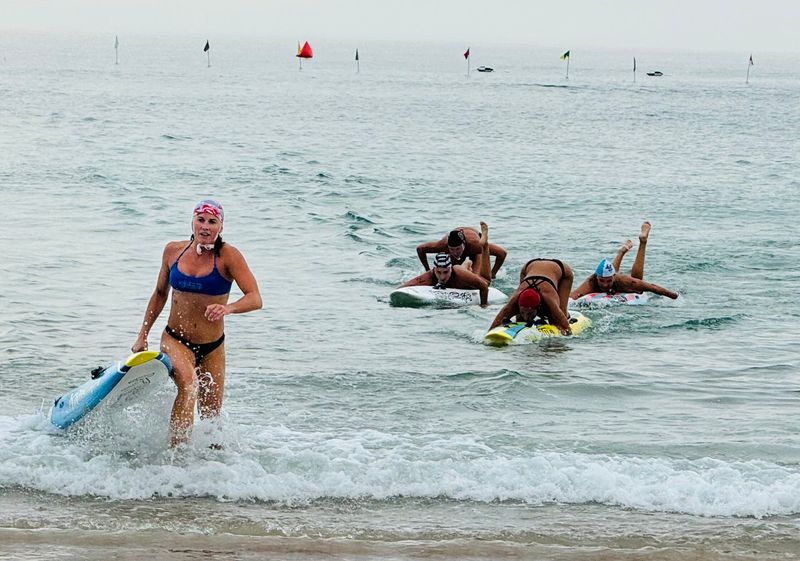 A lifeguard runs to the shore on July 23 on Daytona Beach during the 2025 James P. “Mac” McCarthy Regional Surf Lifesaving Championships.
