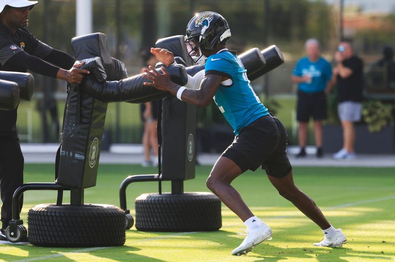 Jacksonville Jaguars wide receiver Travis Hunter (12) drills on a practice dummy during an NFL training camp session at the Miller Electric Center, Wednesday, July 23, 2025, in Jacksonville, Fla. [Corey Perrine/Florida Times-Union]