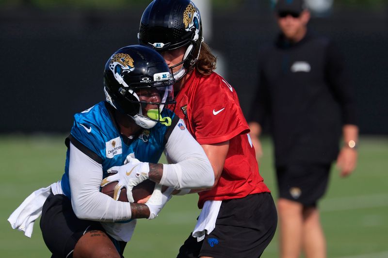 Jacksonville Jaguars quarterback Trevor Lawrence (16) hands off to running back Travis Etienne Jr. (1) during an NFL training camp session at the Miller Electric Center, Wednesday, July 23, 2025, in Jacksonville, Fla. [Corey Perrine/Florida Times-Union]