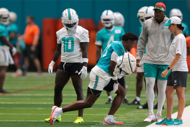 Jul 23, 2025; Miami Gardens, FL, USA; Miami Dolphins cornerback Artie Burns (23) reacts during training camp as wide receiver Tyreek Hill (10) watches at Baptist Health Training Complex. Mandatory Credit: Sam Navarro-Imagn Images