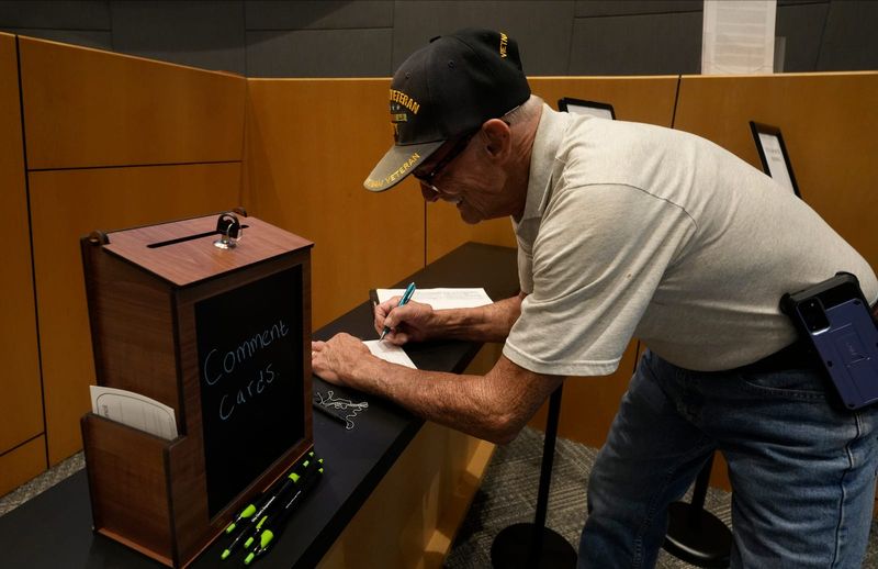 Derek.Frazier, of Cape Coral, fills out a comment card during the Cape Coral city council meeting Wednesday, July 23, 2025.