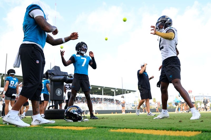 Jacksonville Jaguars wide receivers Brian Thomas Jr. (7), Travis Hunter (12) and Dyami Brown (5) work on reflexes using tennis balls during an NFL training camp session at the Miller Electric Center, Friday, July 25, 2025, in Jacksonville, Fla. [Corey Perrine/Florida Times-Union]