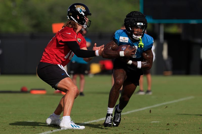 Jacksonville Jaguars quarterback Trevor Lawrence (16) hands off to running back Tank Bigsby (4) during an NFL training camp session at the Miller Electric Center, Friday, July 25, 2025, in Jacksonville, Fla. [Corey Perrine/Florida Times-Union]