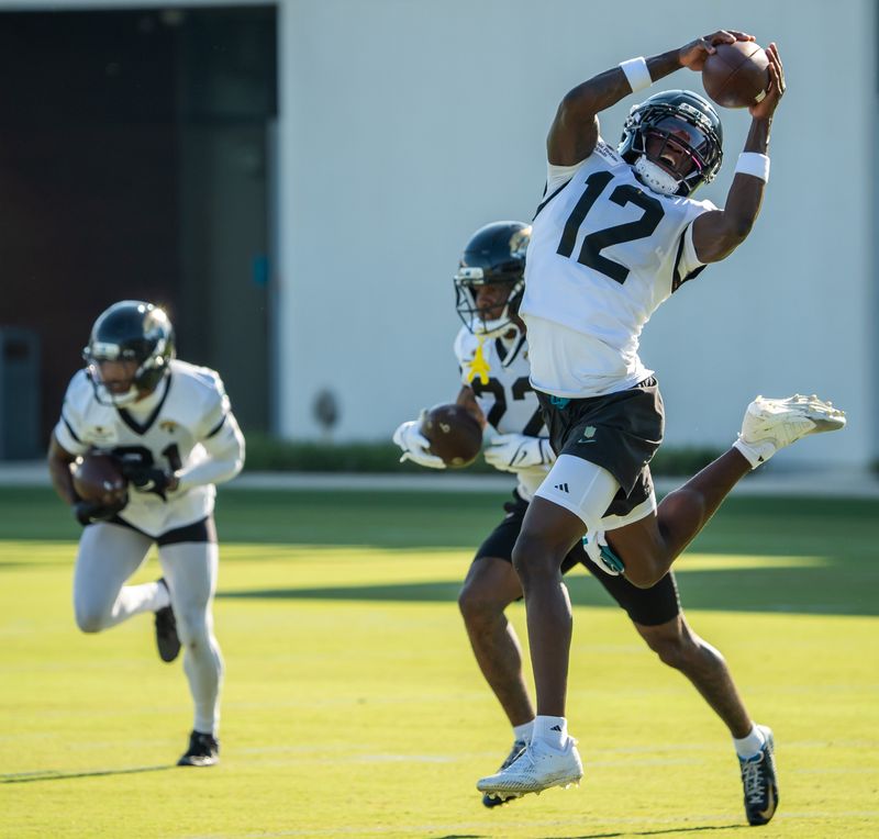 Jacksonville Jaguars wide receiver Travis Hunter (12) hails in a pass while running a drill during an NFL training camp fourth session at the Miller Electric Center, Sunday, July 27, 2025, in Jacksonville, Fla. [Doug Engle/Florida Times-Union]