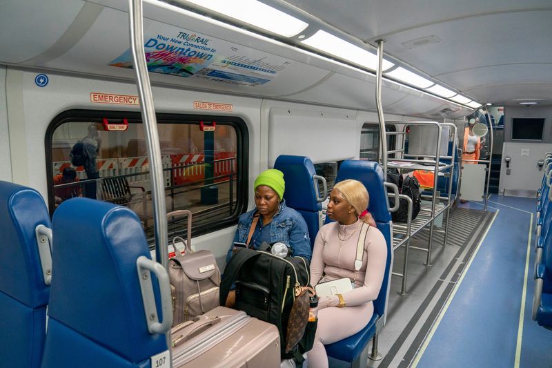Ann Marie Clark, left, and Zamoya Henderson board the Tri-Rail Express train to Miami from West Palm Beach, Florida on July 1, 2024. For $17.50, passengers can take the 90 minute ride to Miami with only 5 stops.