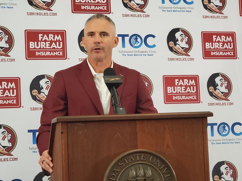 Mike Norvell stands at podium to preview fall camp at his annual luncheon on Tuesday, July 29