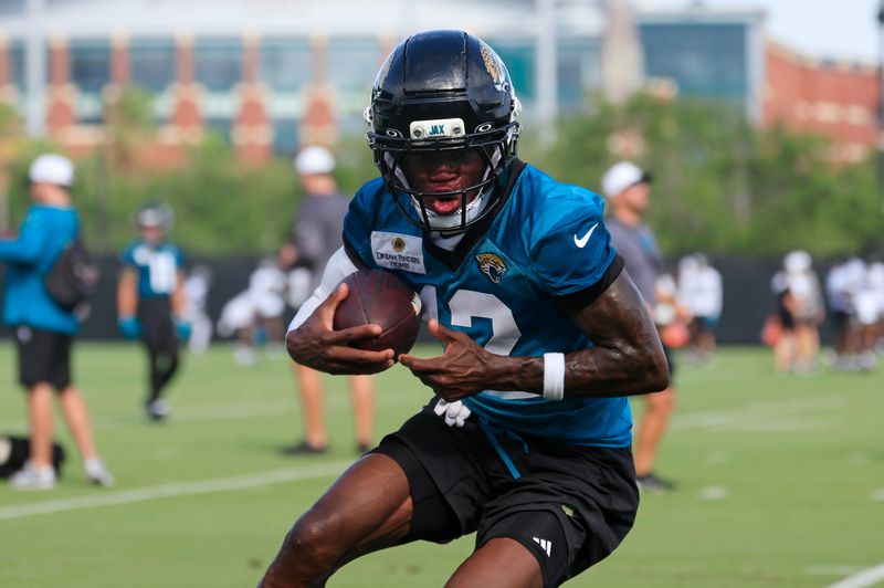 Jacksonville Jaguars wide receiver Travis Hunter (12) runs the ball after a catch during an NFL training camp session at the Miller Electric Center, Wednesday, July 23, 2025