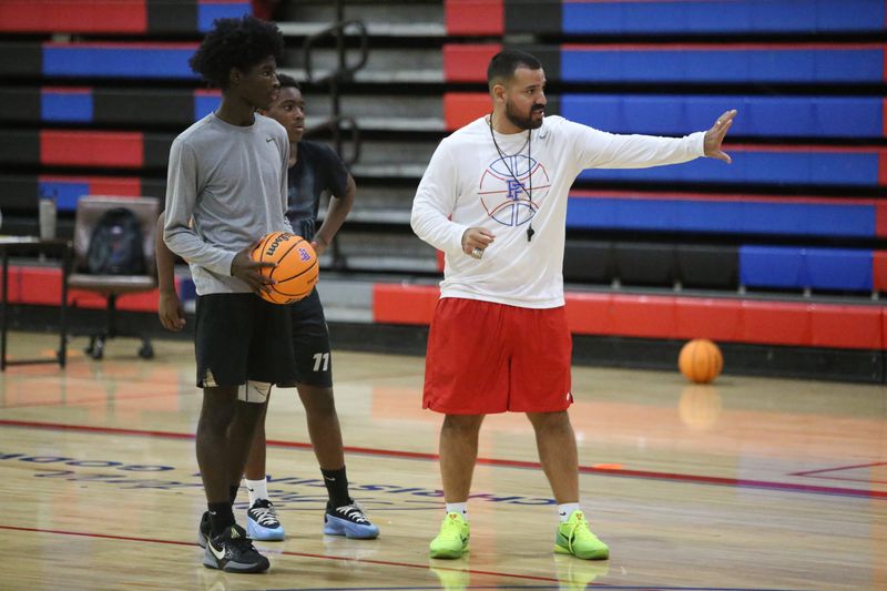 Pine Forest's new boys basketball coach Kevin Barona (right) explains a drill during The Eagle's Nest Basketball Camp on July 29, 2025, at Pine Forest High School.