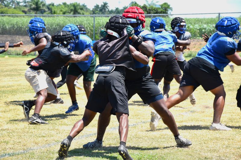 Pahokee's CeeJay Embry grabs hold of a defensive end during practice on July 30, 2025.