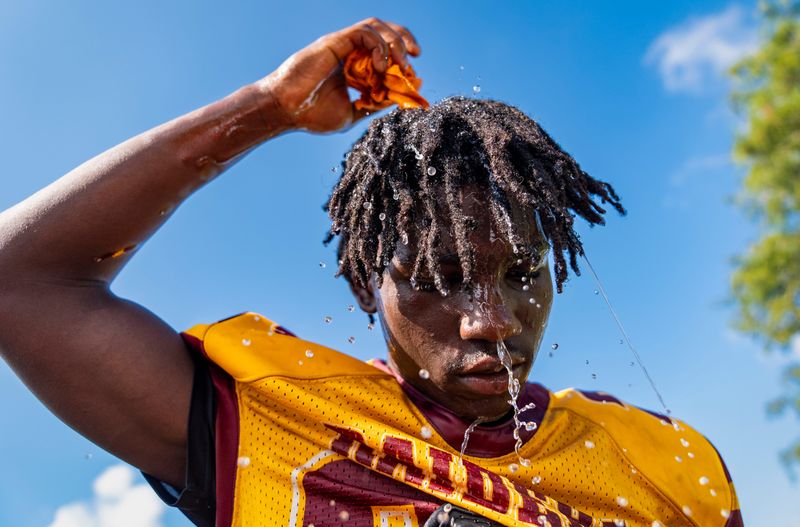 With the heat index above 100 degrees, Glades Central player Anton Jenkins cools off during a water break during practice in Belle Glade, Florida, on July 30, 2025.