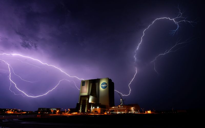 Lightning bolts flash over the Vehicle Assembly Building at Kennedy Space Center August 4, 2025 delaying the launch of a Falcon 9 rocket from nearby Cape Canaveral Space Force Station. The rocket, carrying 28 Starlink satellites, finally launched at 3:57am Eastern. Craig Bailey/FLORIDA TODAY via USA TODAY NETWORK