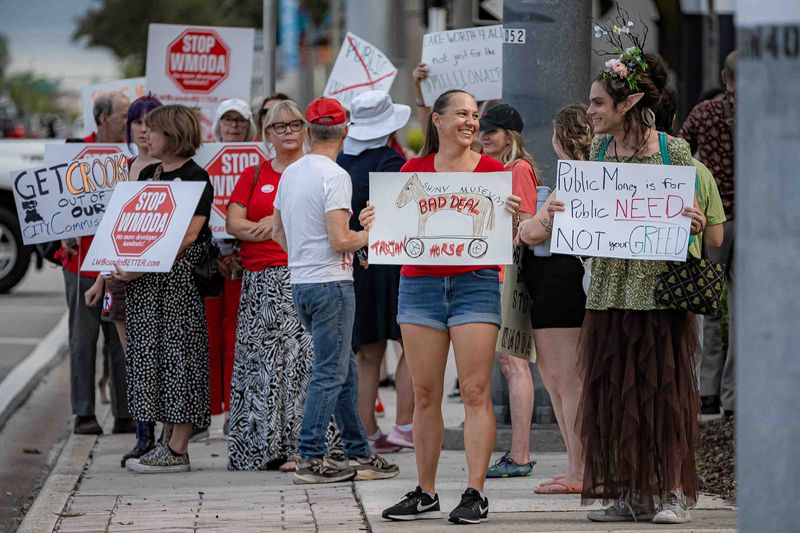 Kim Stokes, former Lake Worth Beach city commissioner, center, leads an Aug. 6, 2025, protest outside City Hall over a plan to build a museum with public funds. Her nonprofit, Lake Worth For All, opposes all the ballot questions in the Tuesday, March 10, city election.