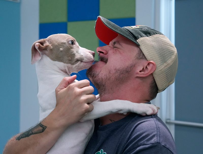 Kelly Cowart gets some affection from Boop Noodle during a photo session at the Halifax Humane Society during the Clear the Shelters national campaign to help get pets adopted, Tuesday, Aug. 5, 2025.