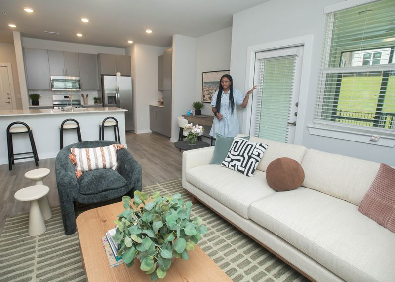 Community manager Alisha Wright gives a tour of the living room in a 2-bedroom apartment at Ascend at Pathstone in Pensacola on Aug. 6, 2025.
