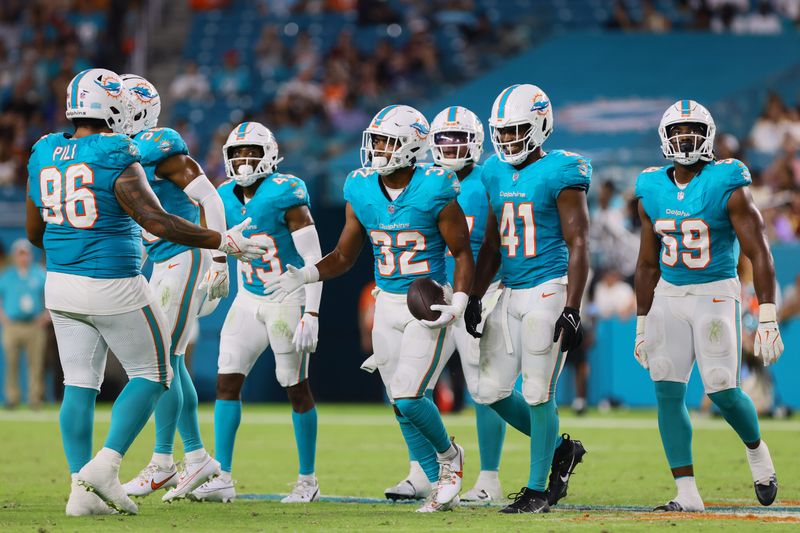 Aug 17, 2024; Miami Gardens, Florida, USA; Miami Dolphins safety Patrick McMorris (32) celebrates with teammates after recovering a fumble against the Washington Commanders during the fourth quarter of a preseason game at Hard Rock Stadium. Mandatory Credit: Sam Navarro-USA TODAY Sports