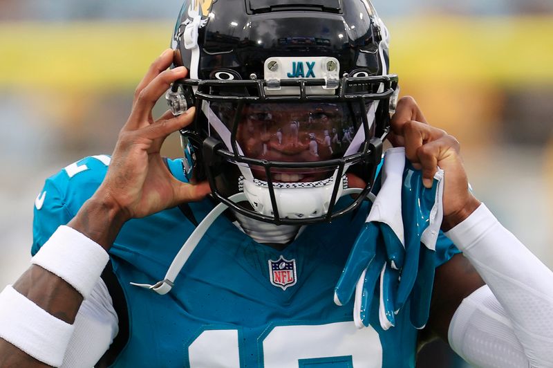 Jacksonville Jaguars wide receiver Travis Hunter (12) puts on his helmet before an NFL preseason matchup at EverBank Stadium, Saturday, Aug. 9, 2025 in Jacksonville, Fla. [Corey Perrine/Florida Times-Union]