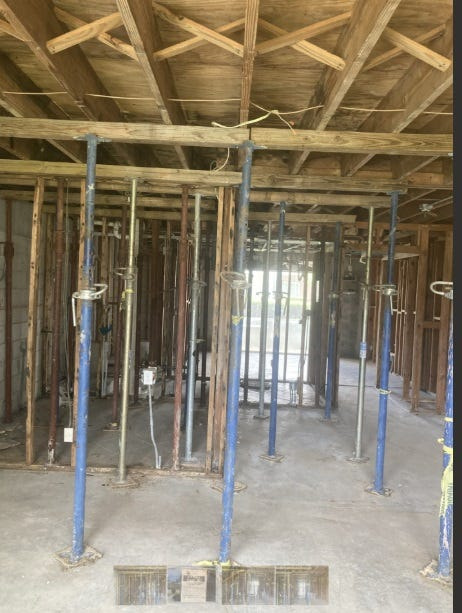 The Century Village building in West Palm Beach supported by posts following a flood in an upstairs unit that caused structural damage. Officials at the complex have called on county building officials to force the association to make needed repairs.