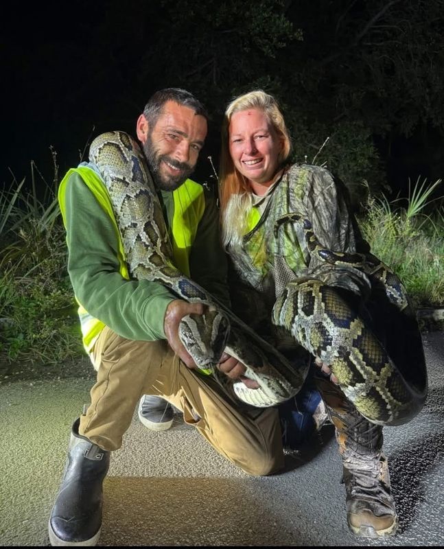 Python hunter Aaron Mann, left, won $1,000 for capturing 87 Burmese pythons in July 2025. Mann participated in the South Florida Water Management District's python incentive program. Next to Mann is Christina Kraus.