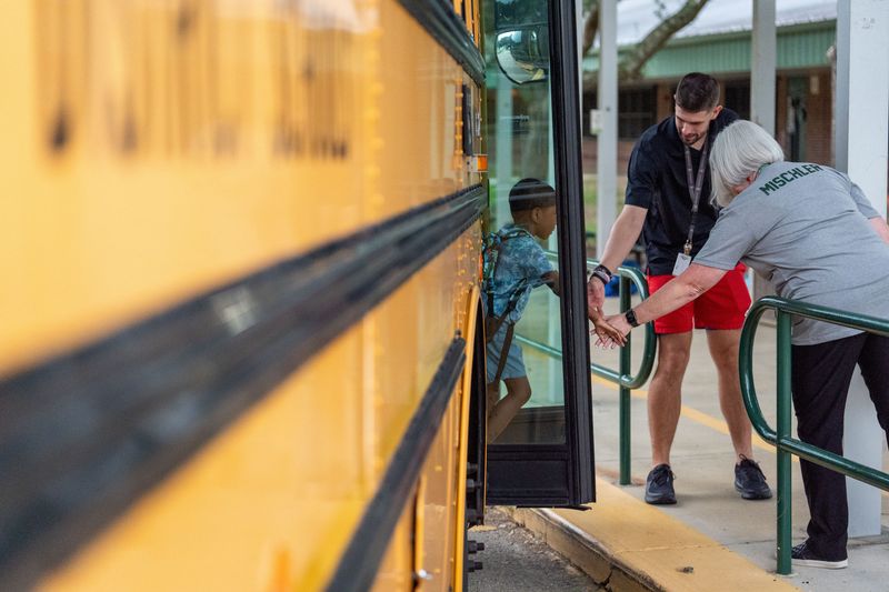 Canopy Oaks Elementary School students step off the bus and head to class on the first day school Monday, Aug. 11, 2025.