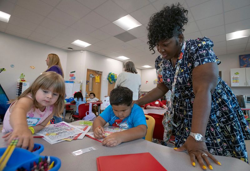West Pensacola's Assistant Principal Latris Garner encourages the work of kindergarten students Abby Phillips and Pedro Gonzalez on their first day of school on August 11, 2025.