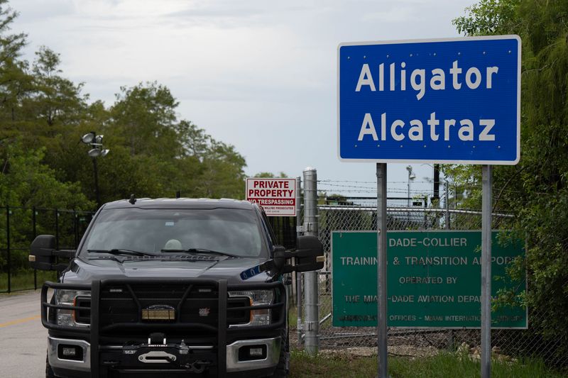 Police officers park outside Alligator Alcatraz in Ochopee, Florida, during the vigil Aug. 10, 2025.